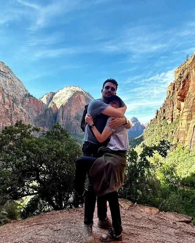 Morgan and Spencer hugging beneath red cliffs